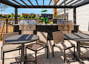 Thumbnail 75 of 98 - A patio with a table and chairs under a roof at The Beaumont Apartments, Bozeman, Montana 59715