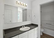 Thumbnail 26 of 43 - A bathroom with a sink, mirror, and toilet. at Oakstone Apartments, Clearfield, Utah