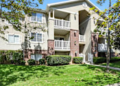 Thumbnail 7 of 26 - A large apartment building with a green lawn in front.at Country Oaks Apartments, Clearfield, UT 84015