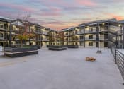 Thumbnail 39 of 48 - an empty courtyard with apartment buildings with a colorful sky above it at River Walk Apartments, Boise, Idaho