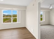 Thumbnail 6 of 98 - A room with a large window overlooking a road and greenery at The Beaumont Apartments, Bozeman, Montana 59715