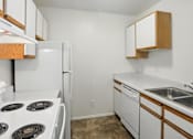 Thumbnail 21 of 26 - A kitchen with white appliances and wooden cabinets.at Country Oaks Apartments, Utah, 84015