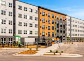 Thumbnail 60 of 98 - A modern apartment complex with a playground in front at The Beaumont Apartments, Montana