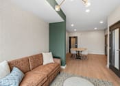 Thumbnail 48 of 98 - Coworking spaces with a brown couch and a small table with chairs at The Beaumont Apartments, MT 59715