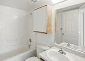 Thumbnail 20 of 26 - A white bathroom with a toilet, sink, and bathtub.at Country Oaks Apartments, Utah
