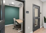 Thumbnail 40 of 98 - Resident conference room with a green wall and a white chair at The Beaumont Apartments, MT 59715