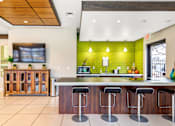 Thumbnail 20 of 35 - a kitchen with green tiles and a bar with stools at Corso Apartments, Missoula, MT
