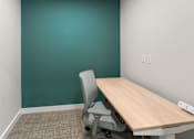 Thumbnail 41 of 98 - A room with a green wall and a wooden table with a grey chair at The Beaumont Apartments, Bozeman, MT