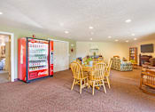 Thumbnail 14 of 31 - a living room with a table and chairs and a refrigerator