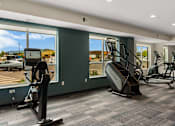 Thumbnail 30 of 98 - A gym with treadmills, elliptical machines, and a rowing machine at The Beaumont Apartments, Montana, 59715