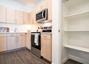 Thumbnail 2 of 52 - A kitchen with wooden cabinets and a microwave above the stove.at Copestone Apartments, Idaho