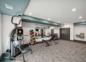 Thumbnail 15 of 51 - A gym with a variety of equipment including a treadmill, weights, and a bench.