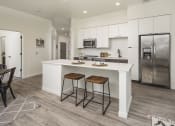 Thumbnail 14 of 26 - a kitchen with a large island with two stools
