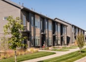 Thumbnail 24 of 26 - a row of townhomes with a sidewalk and grass
