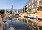Thumbnail 22 of 26 - a water feature sits in front of a row of buildings