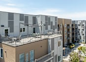 Thumbnail 14 of 29 - A modern apartment complex with balconies and a mix of beige and white exterior colors.