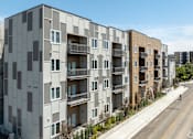 Thumbnail 4 of 29 - A row of modern apartment buildings with balconies and windows.