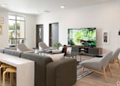 Thumbnail 7 of 29 - A modern living room with a grey sofa, a white table, and a television.