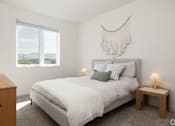 Thumbnail 13 of 29 - A bedroom with a large bed, a nightstand, and a window with a view of the mountains.