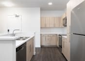 Thumbnail 21 of 29 - A kitchen with a stainless steel refrigerator and wooden cabinets.