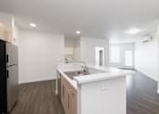 Thumbnail 28 of 29 - A kitchen with white cabinets and a stainless steel refrigerator.