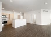 Thumbnail 26 of 29 - A spacious kitchen with wooden floors and white walls.