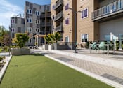 Thumbnail 18 of 29 - Apartment complex with a green lawn in front.