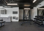 Thumbnail 15 of 28 - a gym with weights and other equipment in the corner of a room at Crosshatch, Garden City