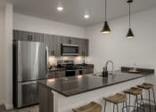 Thumbnail 11 of 28 - a kitchen with a large island and a stainless steel refrigerator at Crosshatch, Idaho, 83714