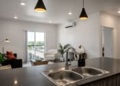 Thumbnail 7 of 28 - a kitchen counter with a sink and a view of a living room at Crosshatch, Idaho, 83714
