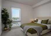 Thumbnail 10 of 28 - a bedroom with a bed and a plant and a window at Crosshatch, Idaho, 83714
