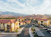 Thumbnail 27 of 28 - A view of a housing complex with a mountain range in the background.