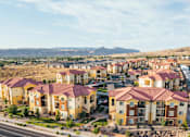 Thumbnail 26 of 28 - A large apartment complex with a parking lot in front.