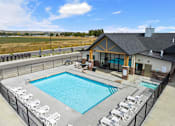 Thumbnail 2 of 45 - A large outdoor swimming pool surrounded by a fence and lounge chairs at The Expo in Billings, MT,