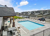 Thumbnail 3 of 45 - A swimming pool with lounge chairs and a fence in front of at The Expo in Billings, MT,