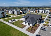 Thumbnail 51 of 64 - A large building with a black roof is surrounded by a parking lot and other buildings. at Silverbrook Apartments, Kalispell 59901