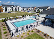Thumbnail 47 of 64 - A swimming pool surrounded by a black fence with a grassy area at Silverbrook Apartments, Kalispell