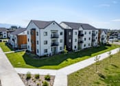 Thumbnail 45 of 64 - A row of modern townhouses with a sidewalk and landscaping in front. at Silverbrook Apartments, Kalispell 59901