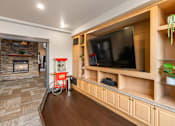 Thumbnail 28 of 38 - A living room with a stone fireplace and a television. at Copper Run at Reserve, Montana