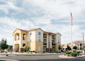 Thumbnail 23 of 28 - A yellow building with a flag on top of it.