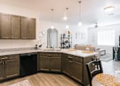 Thumbnail 17 of 28 - A kitchen with dark brown cabinets and a black dishwasher.