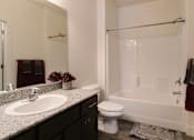 Thumbnail 15 of 28 - A white bathroom with a sink, toilet, and bathtub.