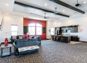 Thumbnail 12 of 28 - A living room with a black couch and a grey rug.