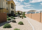 Thumbnail 4 of 28 - A small garden with a gravel path and a few plants in front of a building.