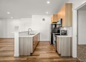 Thumbnail 22 of 64 - A modern kitchen with wooden cabinets and stainless steel appliances at Silverbrook Apartments, Kalispell, MT