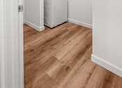 Thumbnail 26 of 64 - A white washing machine is in a small room with wooden floors at Silverbrook Apartments, MT 59901
