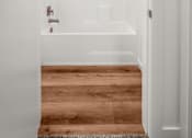 Thumbnail 25 of 64 - A white bathroom with a wooden floor and a white bathtub at Silverbrook Apartments, MT 59901