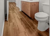Thumbnail 24 of 64 - A spacious bathroom with wooden floors, a wooden vanity, and a mirror above it at Silverbrook Apartments, Kalispell