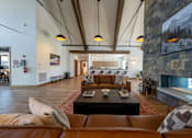 Thumbnail 29 of 64 - A living room with a fireplace and a stone wall. at Silverbrook Apartments, Kalispell 59901
