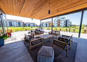 Thumbnail 57 of 64 - A patio with a table and chairs under a wooden roof. at Silverbrook Apartments, Montana